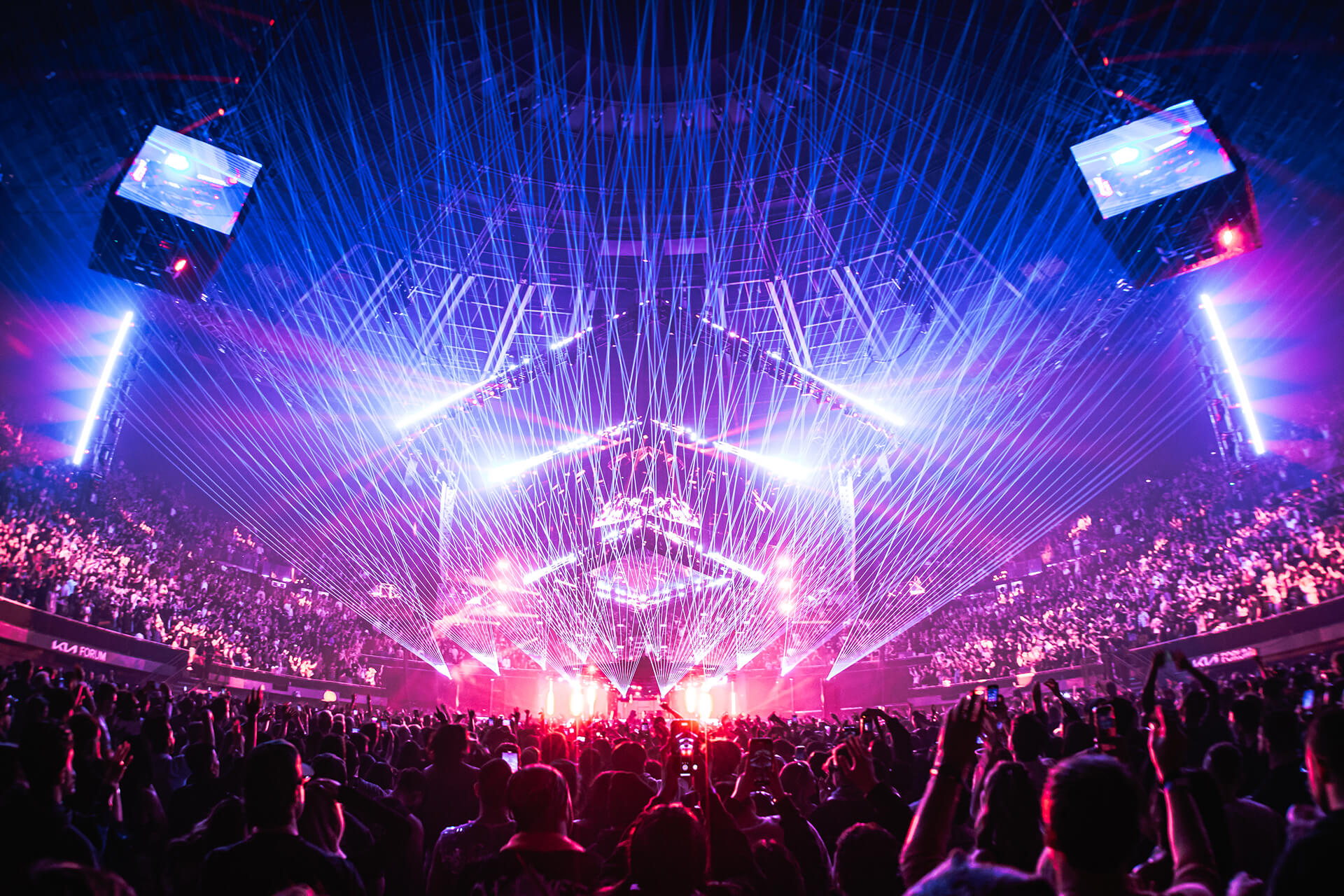 Concert arena lit purple and red with laser beams and crowd at the John Summit Comfort in Chaos tour
