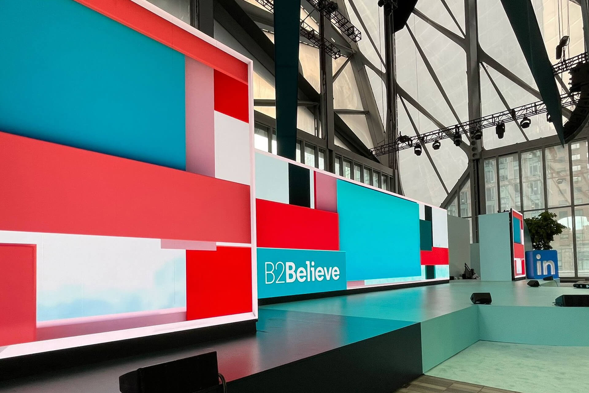 Main stage with a red and teal LED wall and B2Believe branding at LinkedIn's B2Believe event