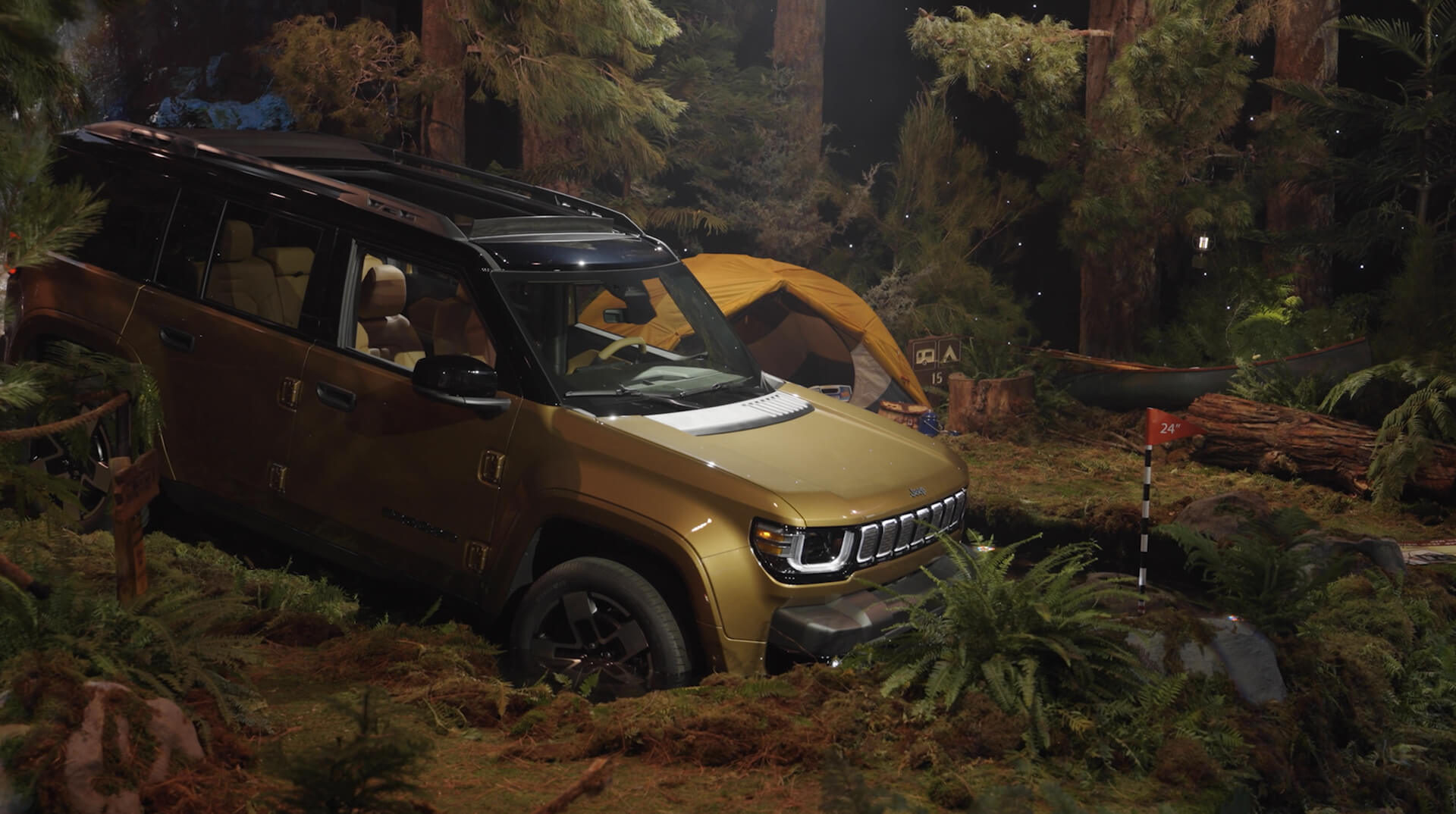 Gold Jeep Recon SUV in an immersive forest camping set at the Jeep Recon reveal