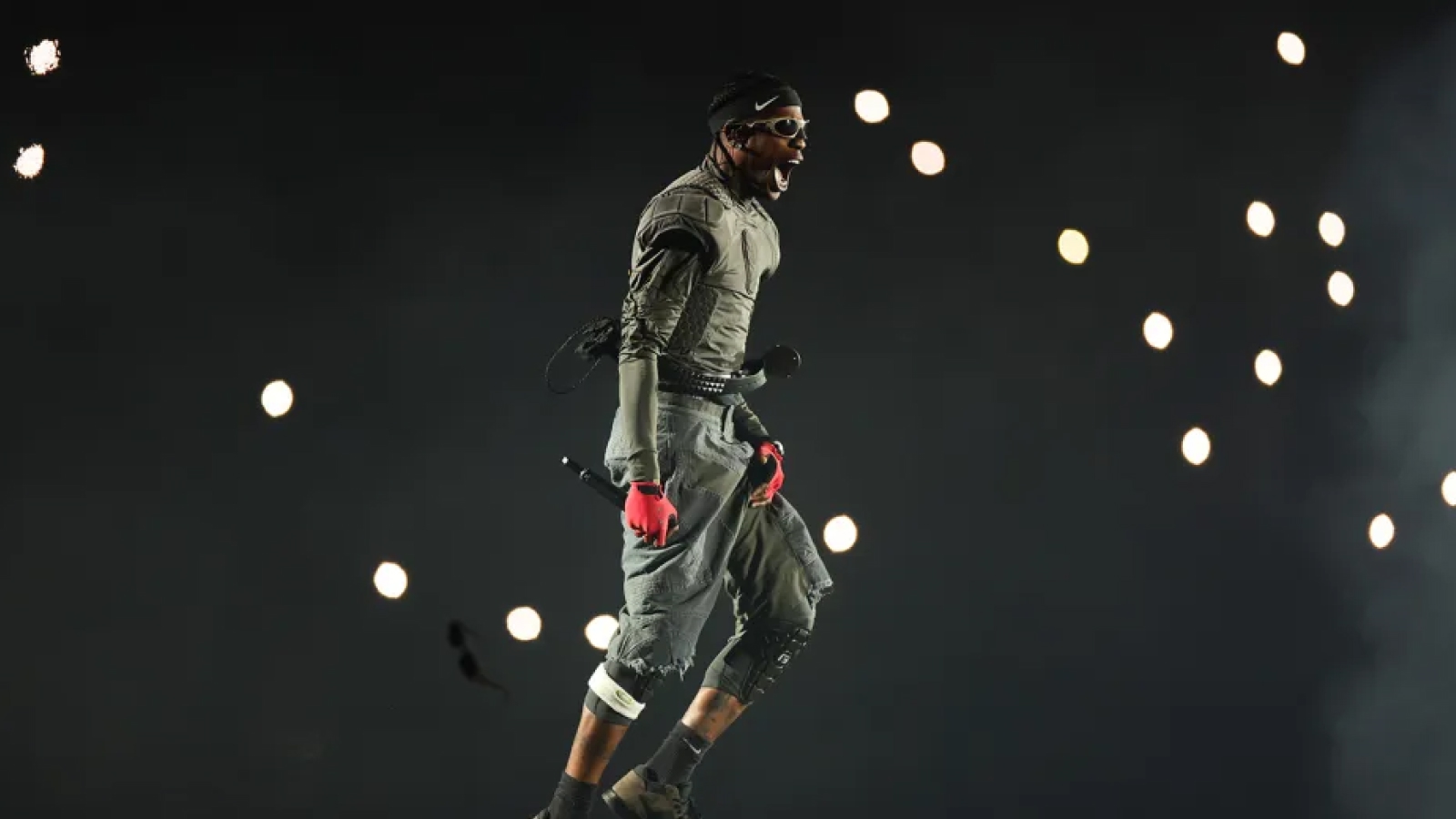 Travis Scott performing mid-stage amid floating orbs of light at Coachella