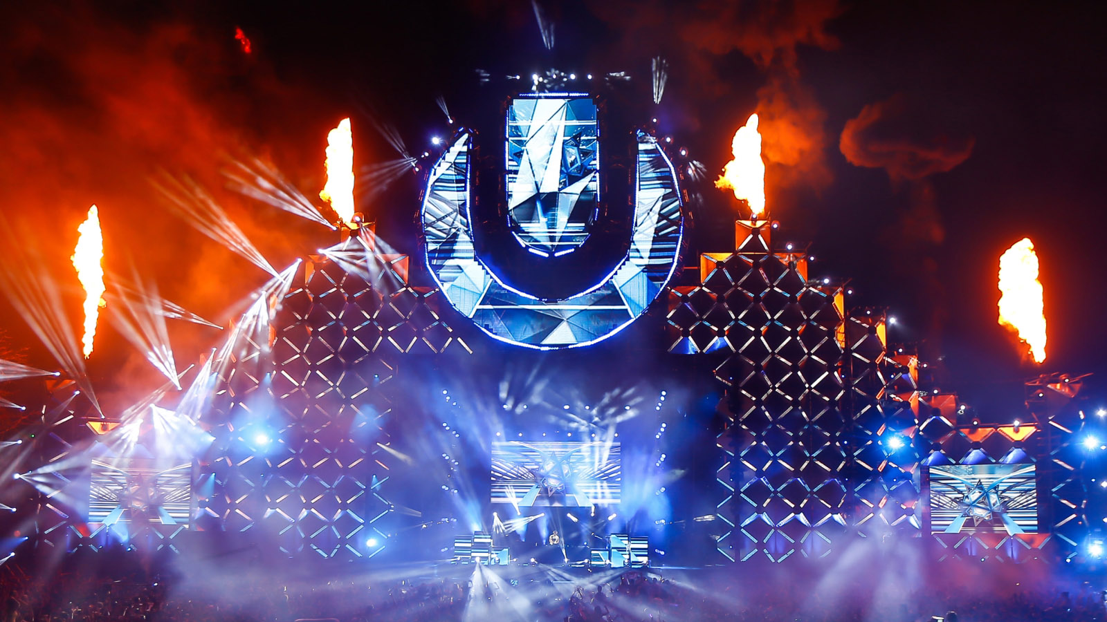Ultra Music Festival main stage with the U logo, pyro flames and laser lighting at night