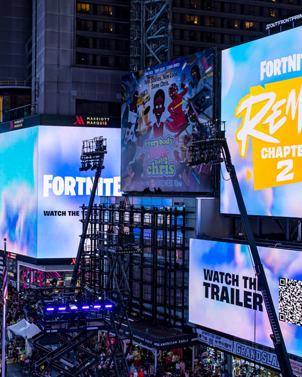 Fortnite and Everybody Still Hates Chris billboards lighting up Times Square at dusk
