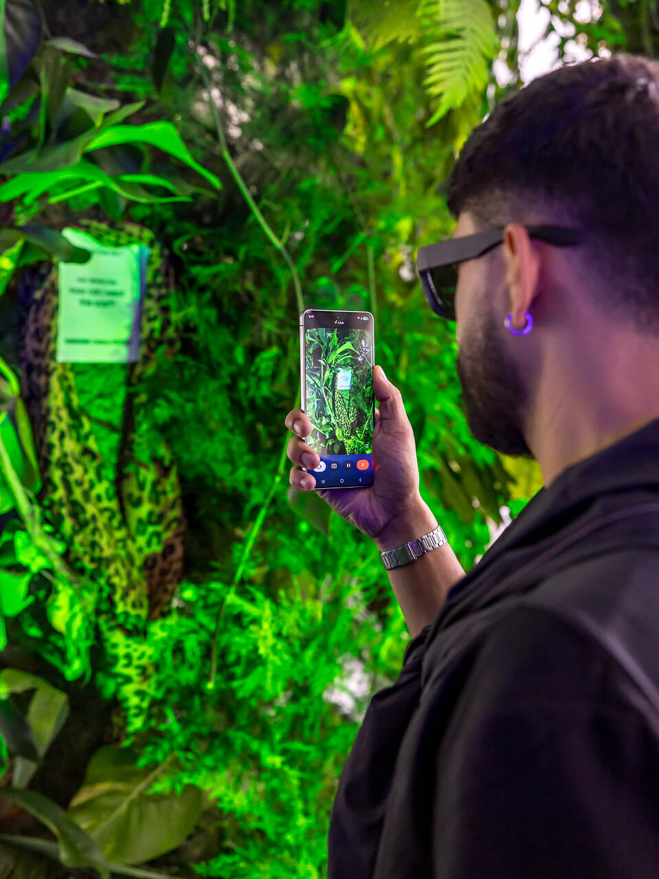 Guest scanning a jungle installation with a Samsung Galaxy phone at an experiential activation