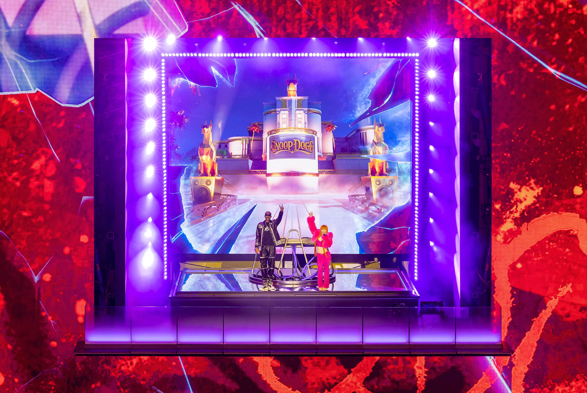 Snoop Dogg and singer perform on stage before a giant purple LED wall with animated backdrop