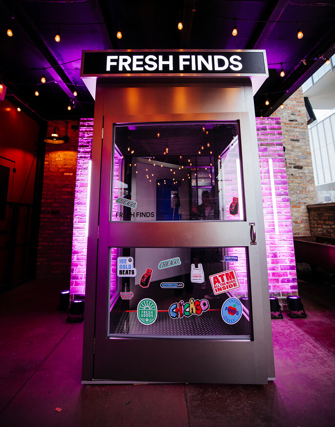 Sticker-covered Fresh Finds phone-booth photo activation under string lights at Spotify Chicago event