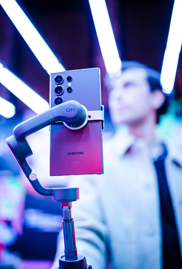 Samsung Galaxy phone on gimbal capturing content under neon tubes at Spotify Fresh Finds