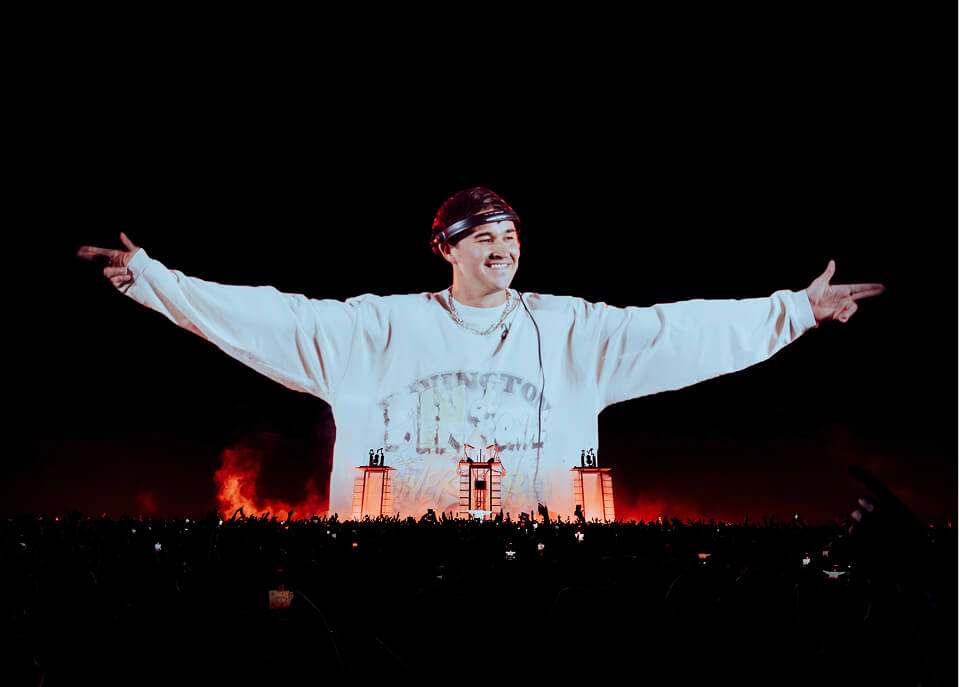 John Summit's giant smiling image projected above the crowd at The Sphere