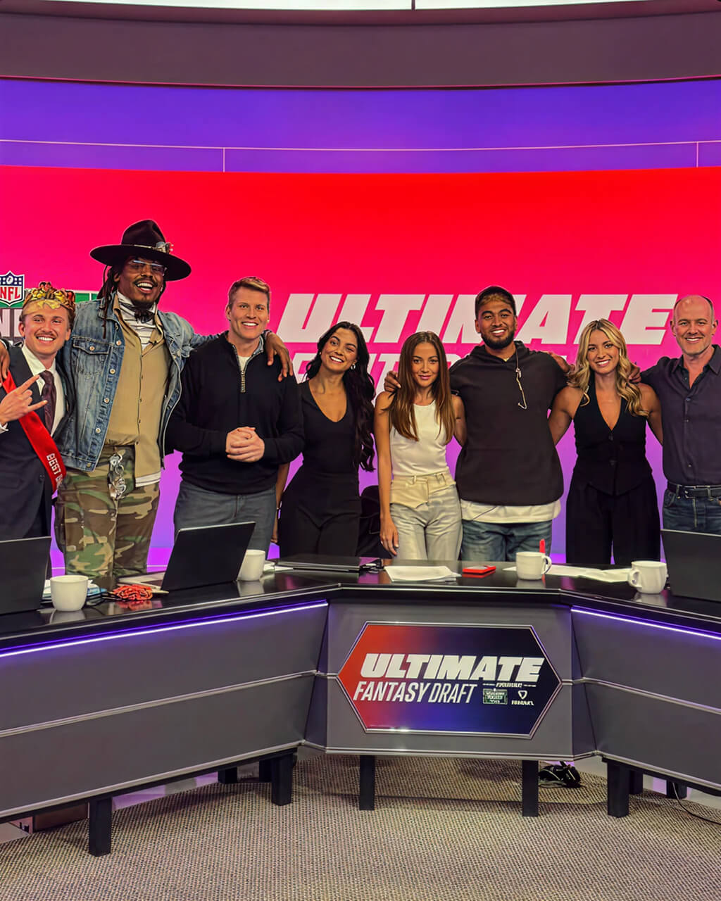 Hosts and athletes posing on the Ultimate Fantasy Draft broadcast set with LED wall