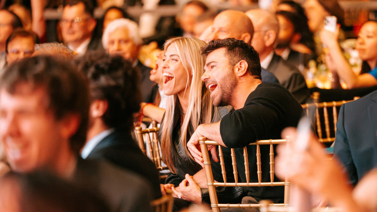 Gala guests laughing and enjoying the show at Evening of Impact
