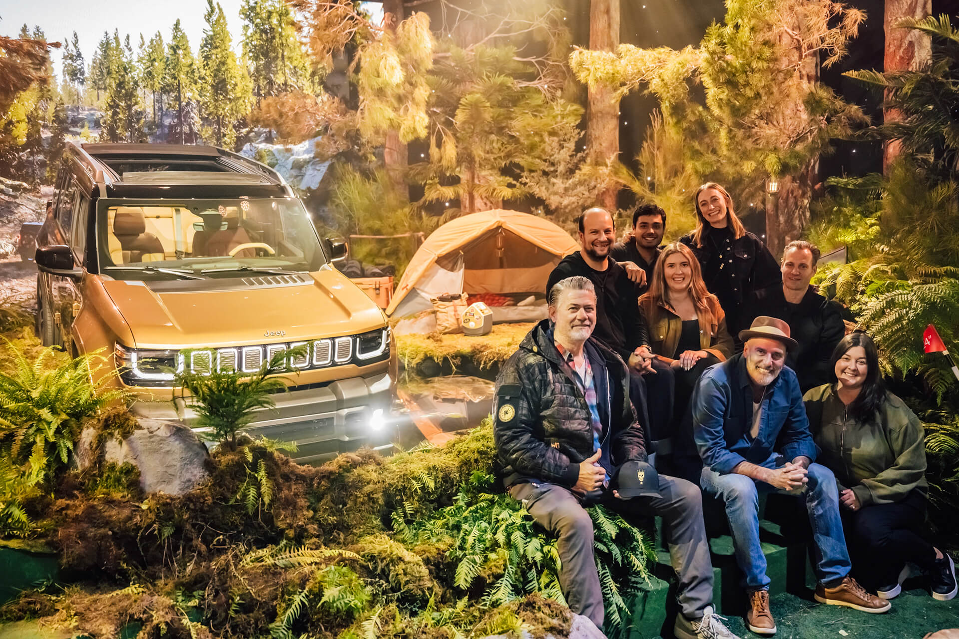 Guests around a vehicle in a forest-themed brand activation set